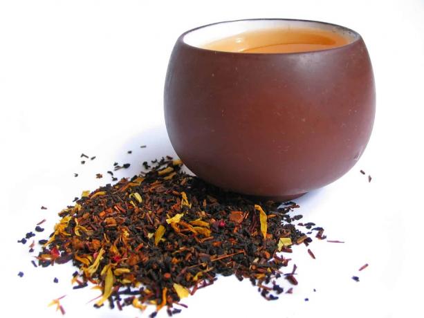 Mix černých a květových čajových lístků s šálkem čaje