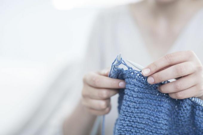 Žena pletení s modrou přízí