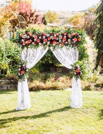 Krajkový závěs a svatební altán s květinovou kyticí