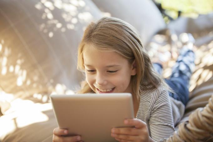Dívka pomocí digitálního tabletu venku