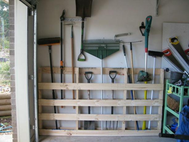 Garážové skladování zahradního nářadí ze starých paletových garáží palet, které využívají recyklaci