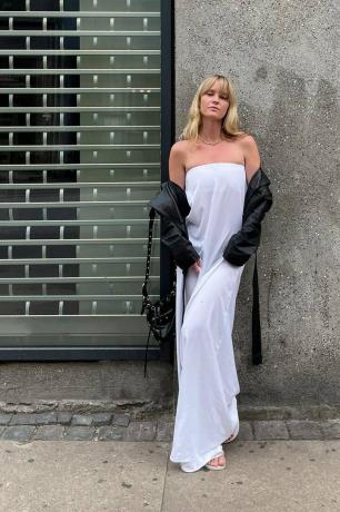 משפיען אופנה סקנדי לובש ז'קט מוטו מעל שמלה לבנה סטרפלס