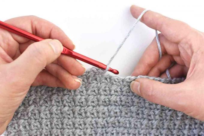 Segurando uma agulha de crochê estilo lápis canhoto