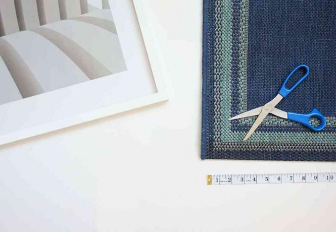Medir dónde cortar el material de la alfombra azul.