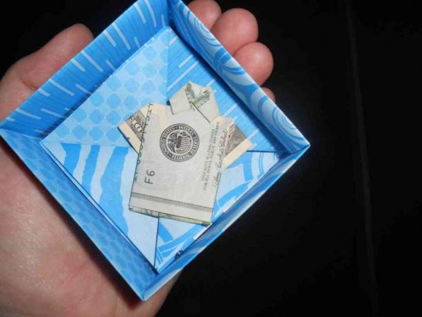 Una pequeña camisa de origami con dinero.