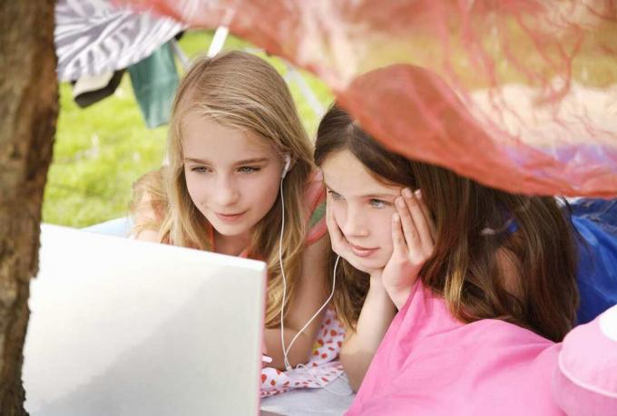 Tüdrukud, kes kasutavad sülearvutit ja MP3 -mängijat