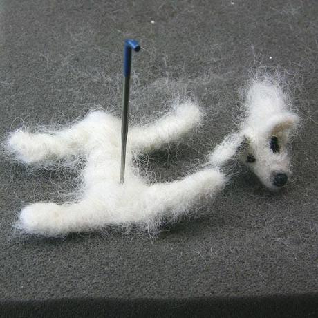 Woll roving é feltrado em uma estrutura de limpador de cachimbo para fazer a base do corpo de um cão de feltro de escala de casa de boneca.