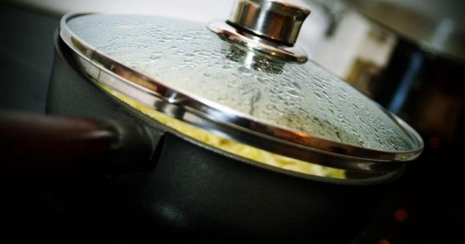 Een metalen diepe pan met stoom in het lood