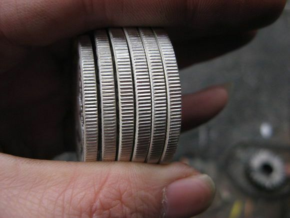 Kanterne på seks falske Morgan -sølvdollar i nogens hånd.
