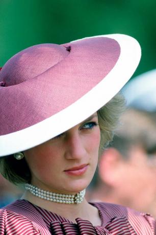 Prinzessin Diana fährt Outfits: Sie trägt einen lila-weißen Hut mit breiter Krempe und ein Perlenhalsband
