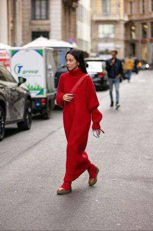 žena nosí červené šaty maxi svetr s červenými botami na ulici