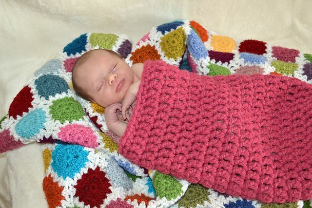Μωρό με κουκούλι βελονάκι μοτίβο ξαπλωμένο σε βελονάκι κουβέρτα