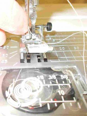Passando a linha em uma agulha de máquina de costura