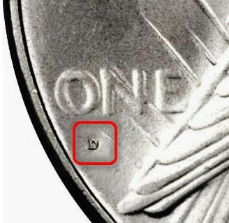 Plasseringen av myntmerket på en fredsdollar under " ONE" på baksiden