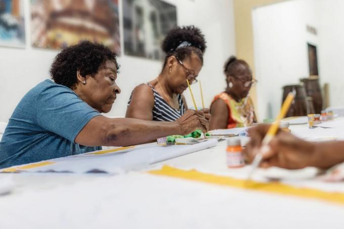 бразильская женщина рисует текстиль в ателье социального проекта