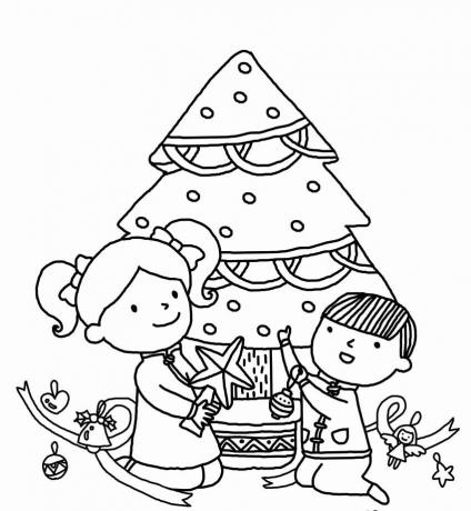 En gutt og jente som pynter et juletre