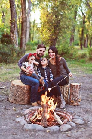 Ideea de fotografiere în aer liber de familie lângă focul de tabără