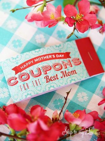 Fotografie kupónu ke Dni matek na stole obklopeném růžovými květy.