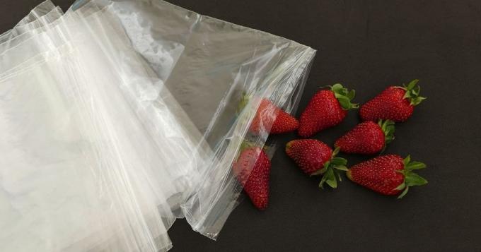 냉동 딸기 냉동 - 지퍼백 옆에 있는 딸기.