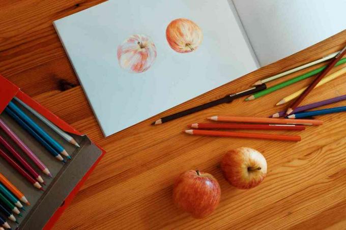 Dibuja dos manzanas con lápices de colores sobre la mesa