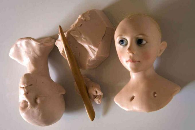As cabeças de bonecas sendo esculpidas em argila