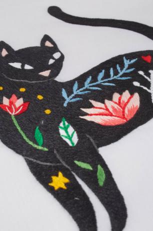 koristeellinen kissa kukilla kirjontakuvio