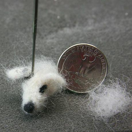Orelhas feltradas e marcas presas a uma cabeça de cachorro feltrada em miniatura de casa de boneca.
