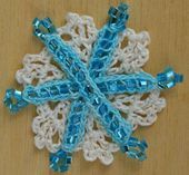 Ornement de flocon de neige au crochet fait de perles, de fil et de fil