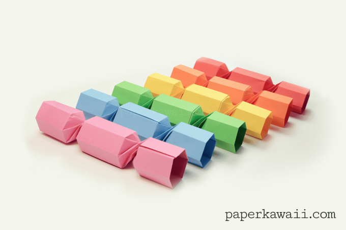Šest origami vánočních držáků sušenek v duhových barvách.