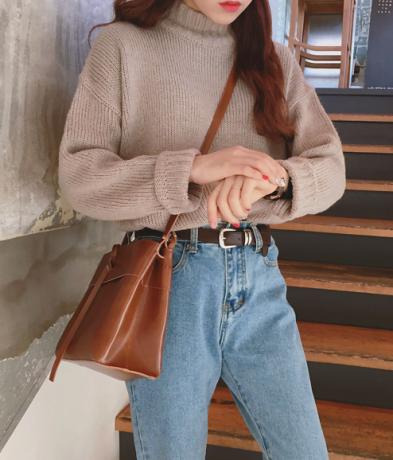 Oblečený sveter z 80. rokov a džínsy s vysokým pásom