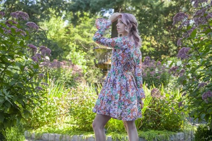 Uma mulher com um vestido costurado em um jardim