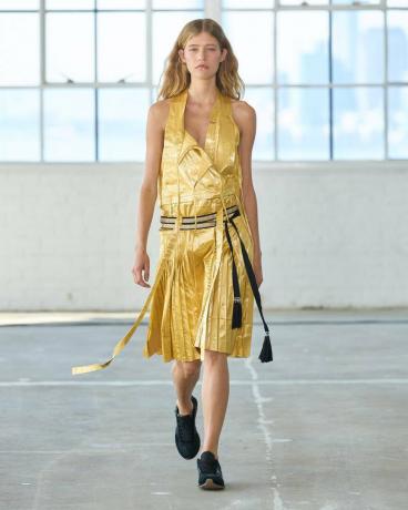 מגמות אופנה של אביב קיץ 2023: דוגמנית לובשת שמלת מידי קפלי זהב על המסלול של אלטוזרה אביב קיץ 2023