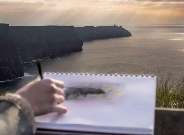 Mujer joven dibujo vista panorámica de los acantilados de Moher, Irlanda