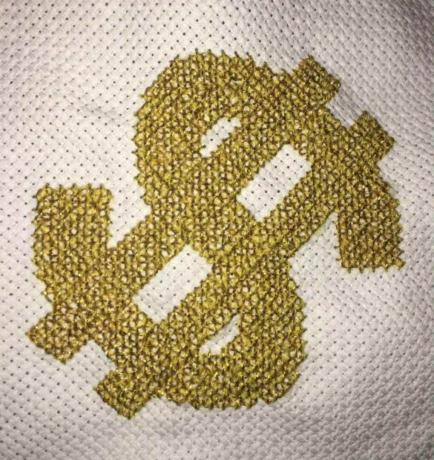 Completado punto de cruz contado de un signo de dólar en oro.