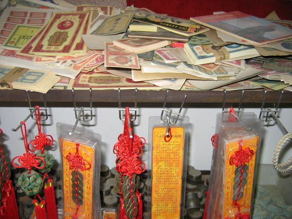 Padělaná měna a turistické zboží vyrobené velkou čínskou operací s falešnými mincemi.