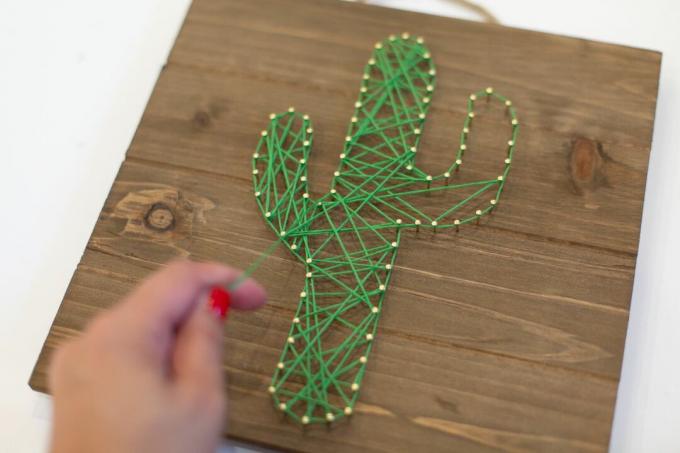 Kreuzen Sie das String-Design an, um niedliche Kaktus-String-Kunst zu erstellen