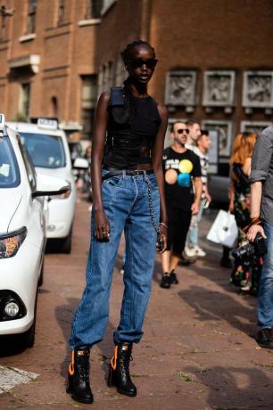 Las mejores botas de invierno: un modelo de estilo urbano con botas con cordones de Prada con jeans holgados y un top negro
