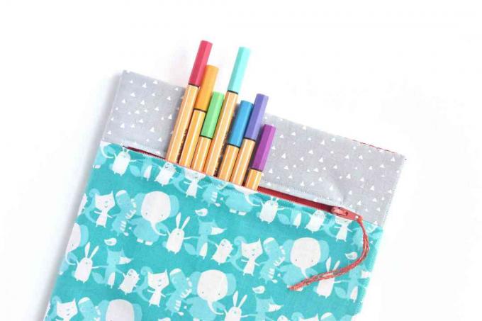 Marcadores de colores en una cubierta de libro de bolsillo con cremallera