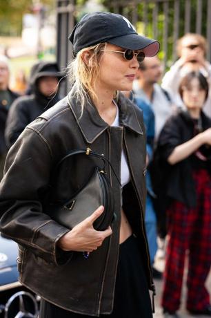 Gigi Hadid nosí koženou tašku přes rameno Prada Arqué.