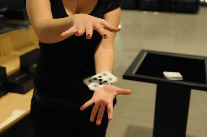 Kvinne utfører magi for å flyte og spinne spillekort
