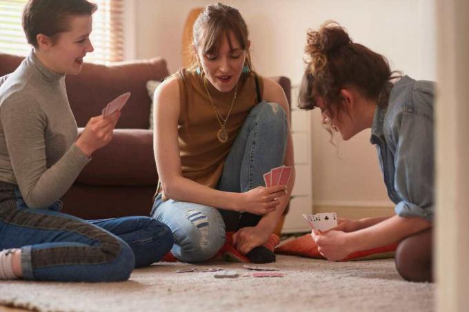 Přátelé hrající karty v obývacím pokoji