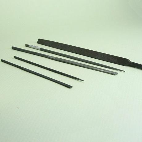 Sortiment miniaturních kovových a dřevěných pilníků pro řemeslné práce.