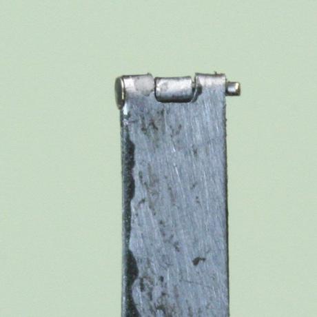 Alfinete de cabeça de joalheiro cortado no comprimento e dobrado para segurar uma dobradiça de escala de caixa de boneca