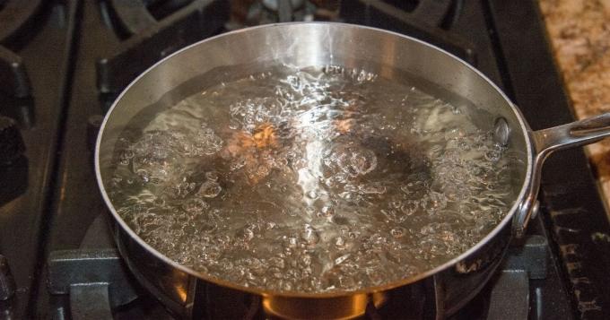Eine tiefe Pfanne auf einem Gasherd mit kochendem Wasser